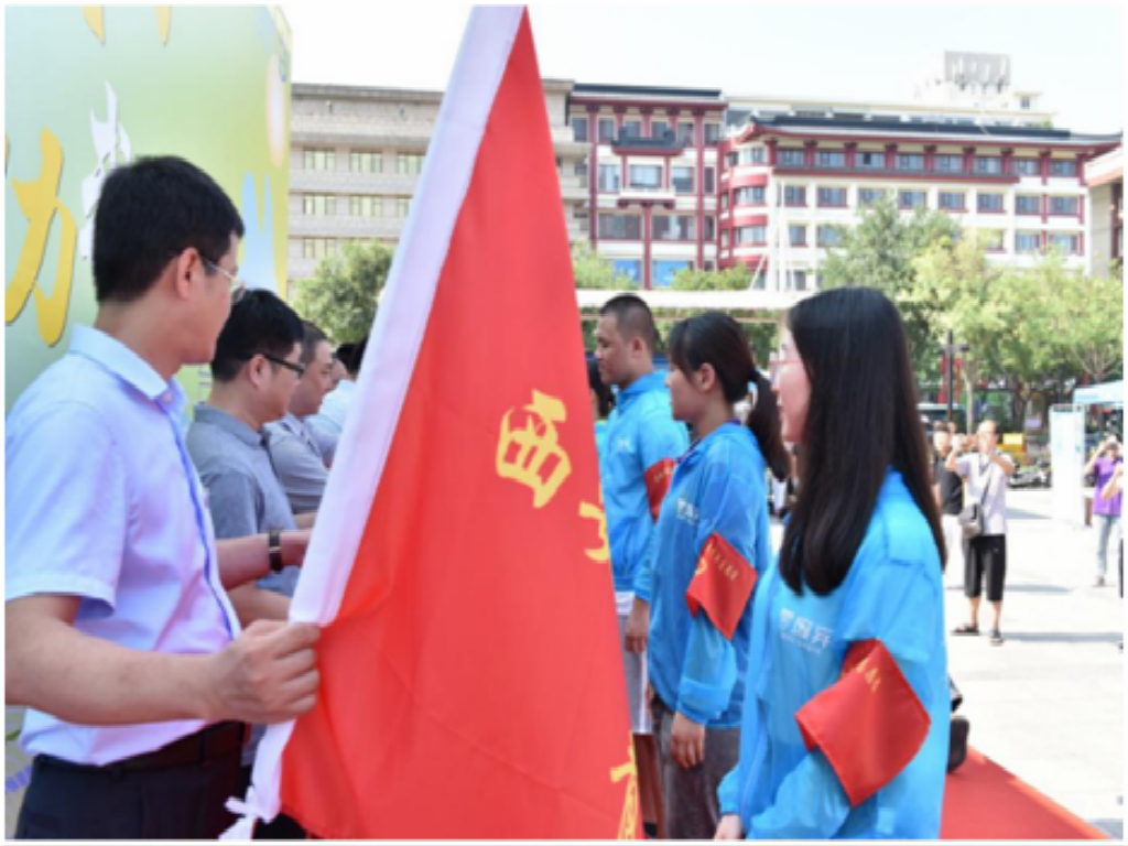 领导向各高校志愿者授旗